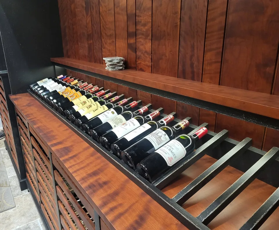 Angled label-forward wine display rack on a figured wood counter.